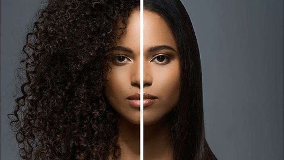 Retrato de mulher com metade do rosto emoldurado por cabelos cacheados volumosos