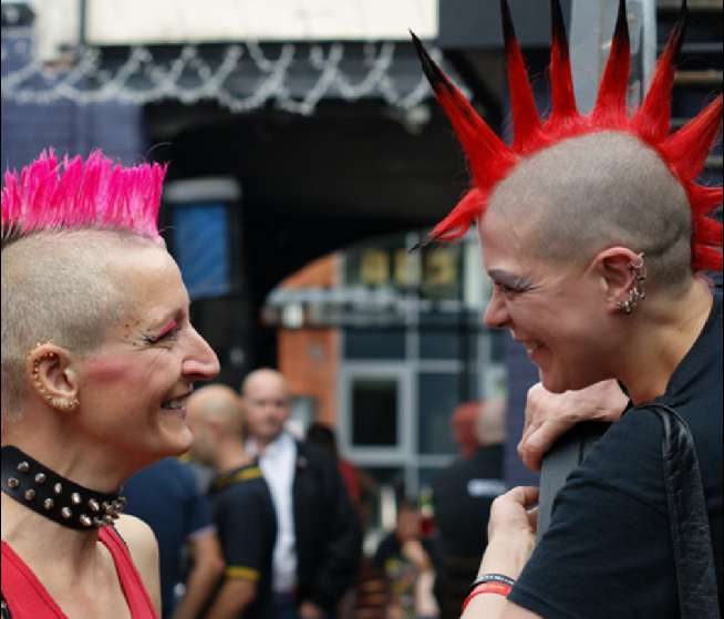 Duas mulheres com moicanos coloridos conversando